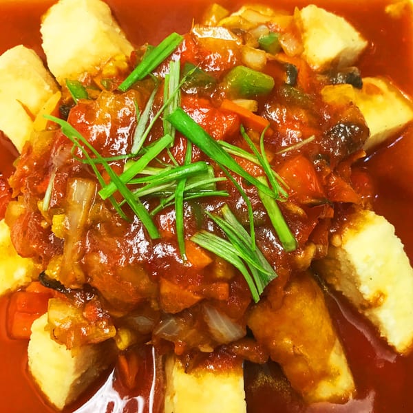 Thai Delight Norman's fried tofu with red curry sauce, bell peppers, onions, and green onions.